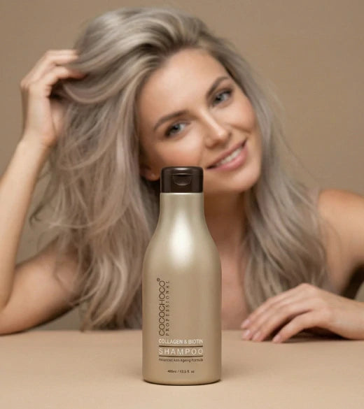 Kvinde med gråt hår holder en flaske shampoo mod en beige baggrund