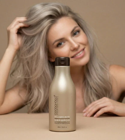 Kvinde med gråt hår holder en flaske shampoo mod en beige baggrund